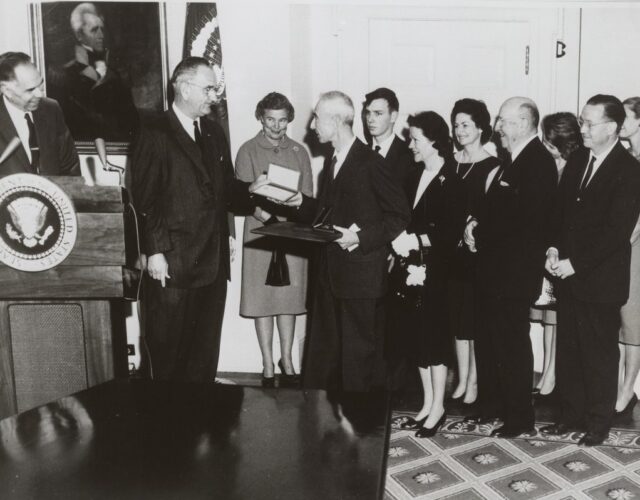 Black and white photo of an award ceremony with group of people