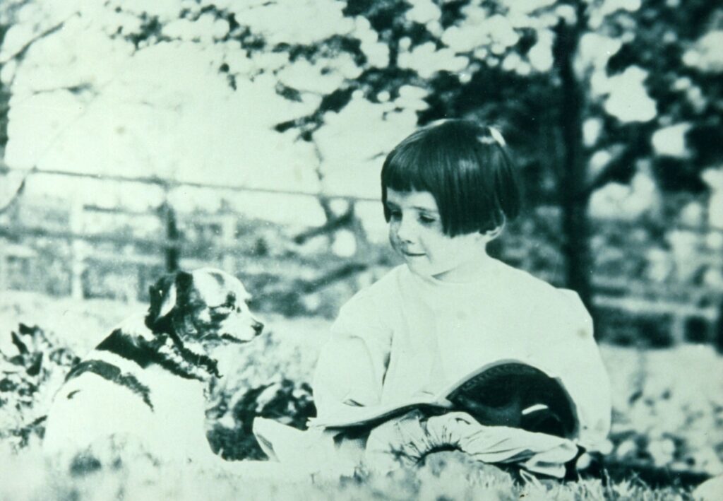 A young Rachel Carson reading a book with her dog Candy, ca. 1910.