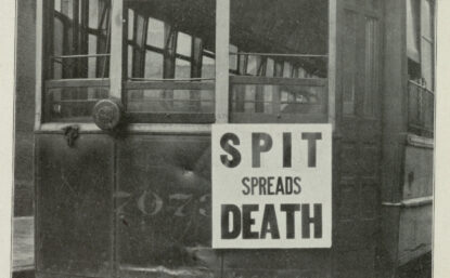 Black and white photograph of a trolley with a sign on front that says "spit spreads death".