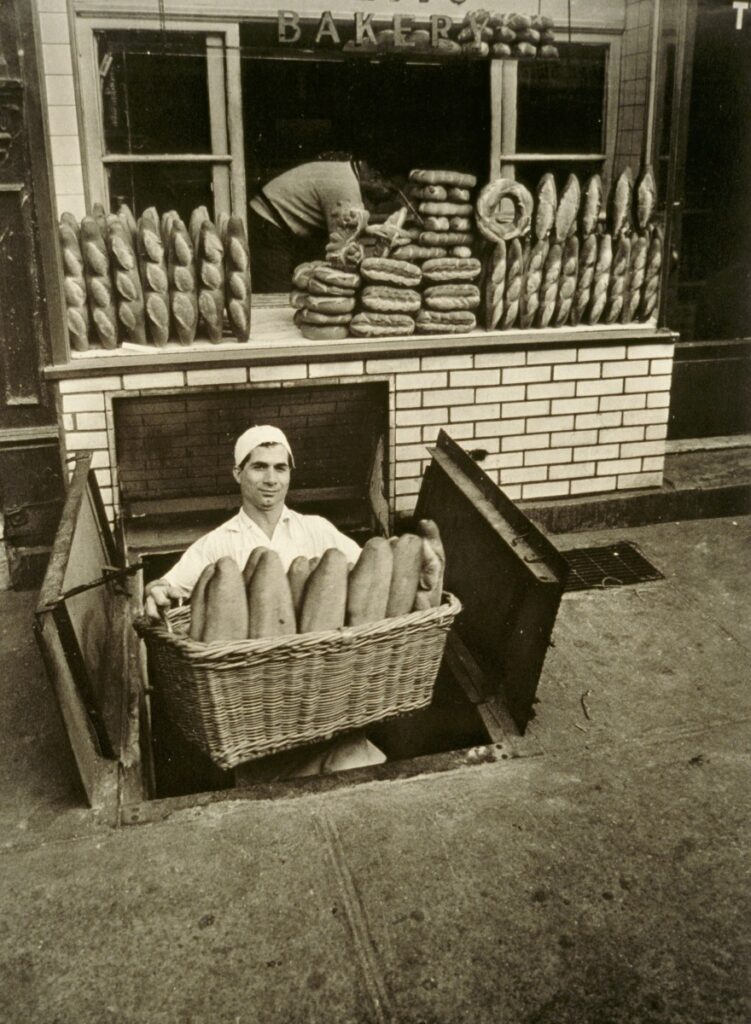 Black and white photo of baker in front of store