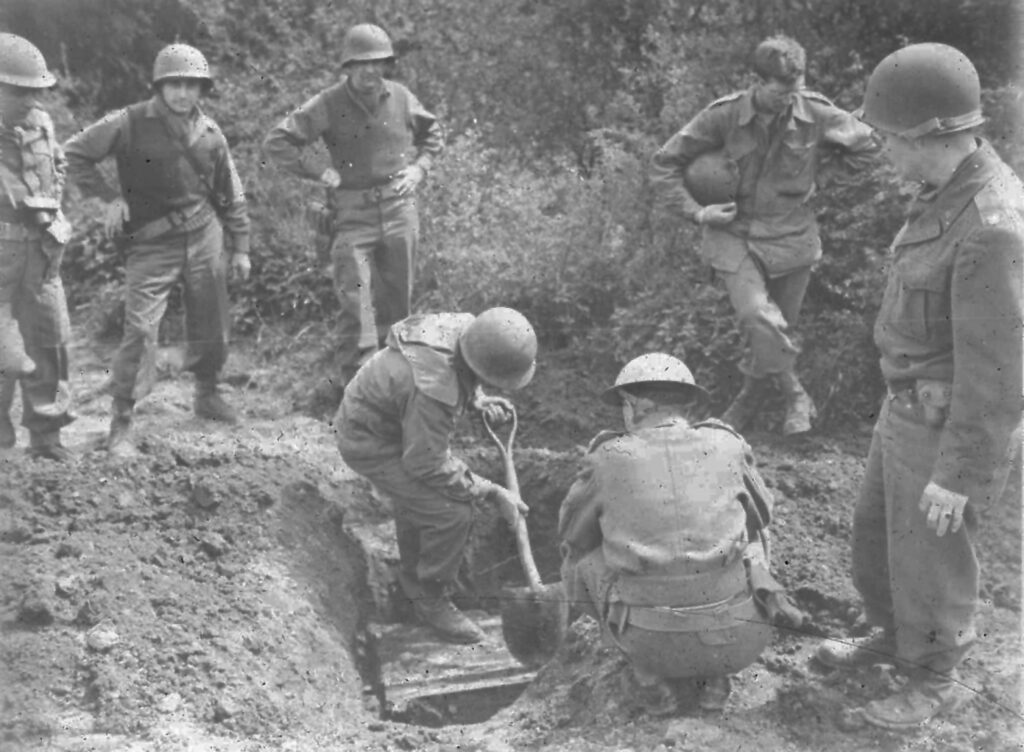 Men in battle fatigues and helmets shoveling