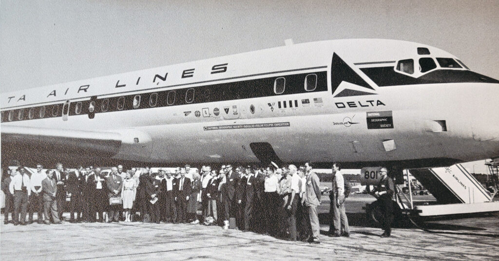 Black and white photo of large group in front of a plane