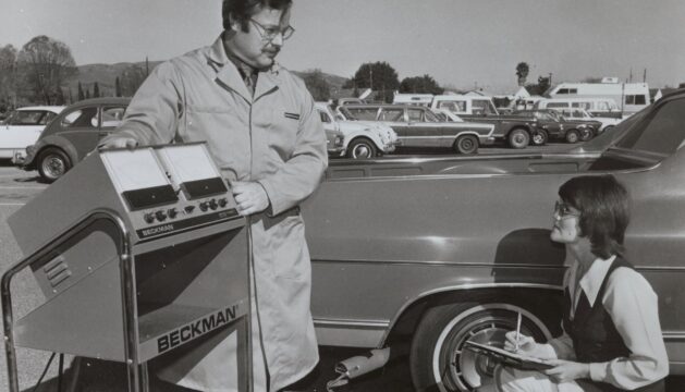 Lab workers testing car exhaust with a scientific instrument