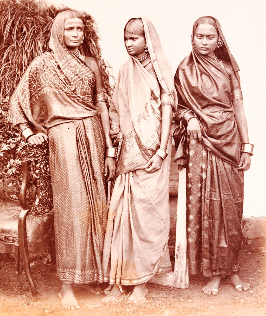 Black and white photo of three women wearing saris