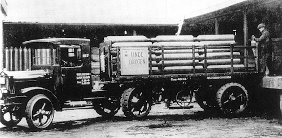 Cylinders of oxygen being loaded on a tractor-trailer truck (1914) owned by the Linde Air Products Company. 