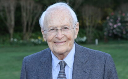 Rosenkranz in a suit and tie, smiling