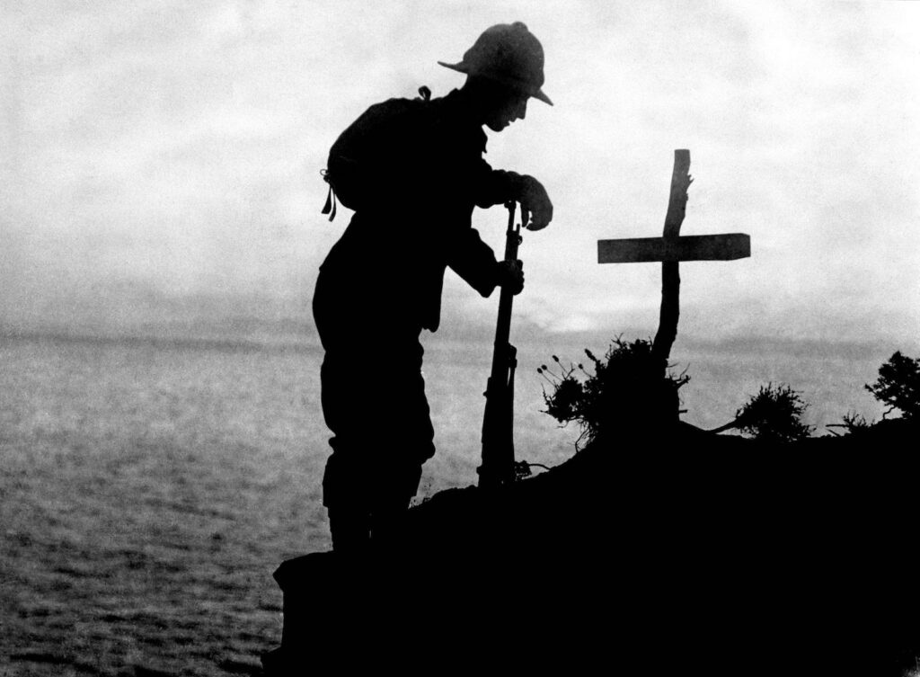 Black and white silhouette photo of soldier and grave marker