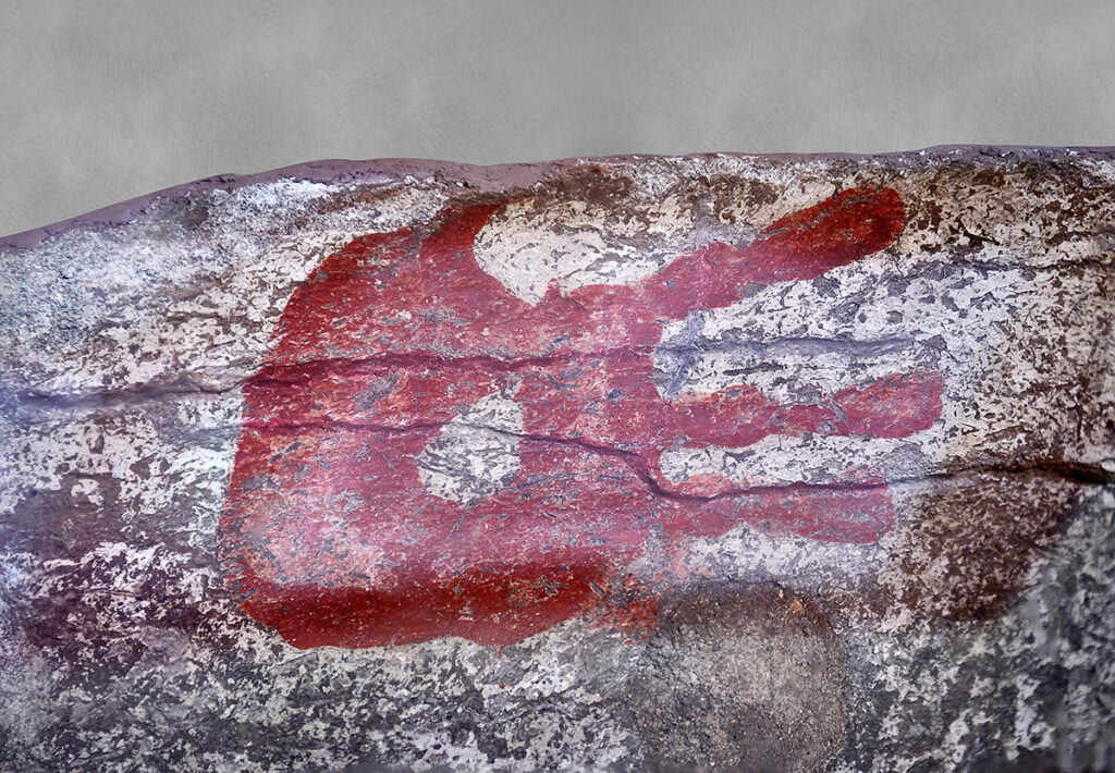 Red handprint on stone wall