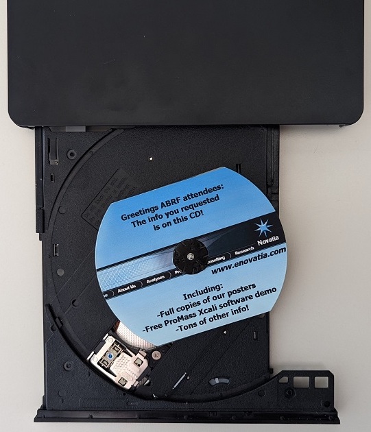 A blue and black S shaped CD in a black disk drive with a spindle