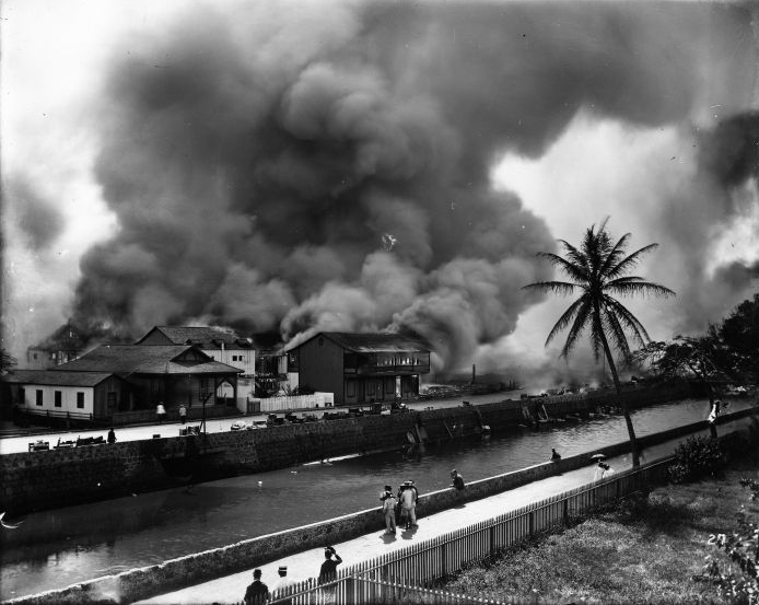 Aerial photograph of buildings on fire across a canal