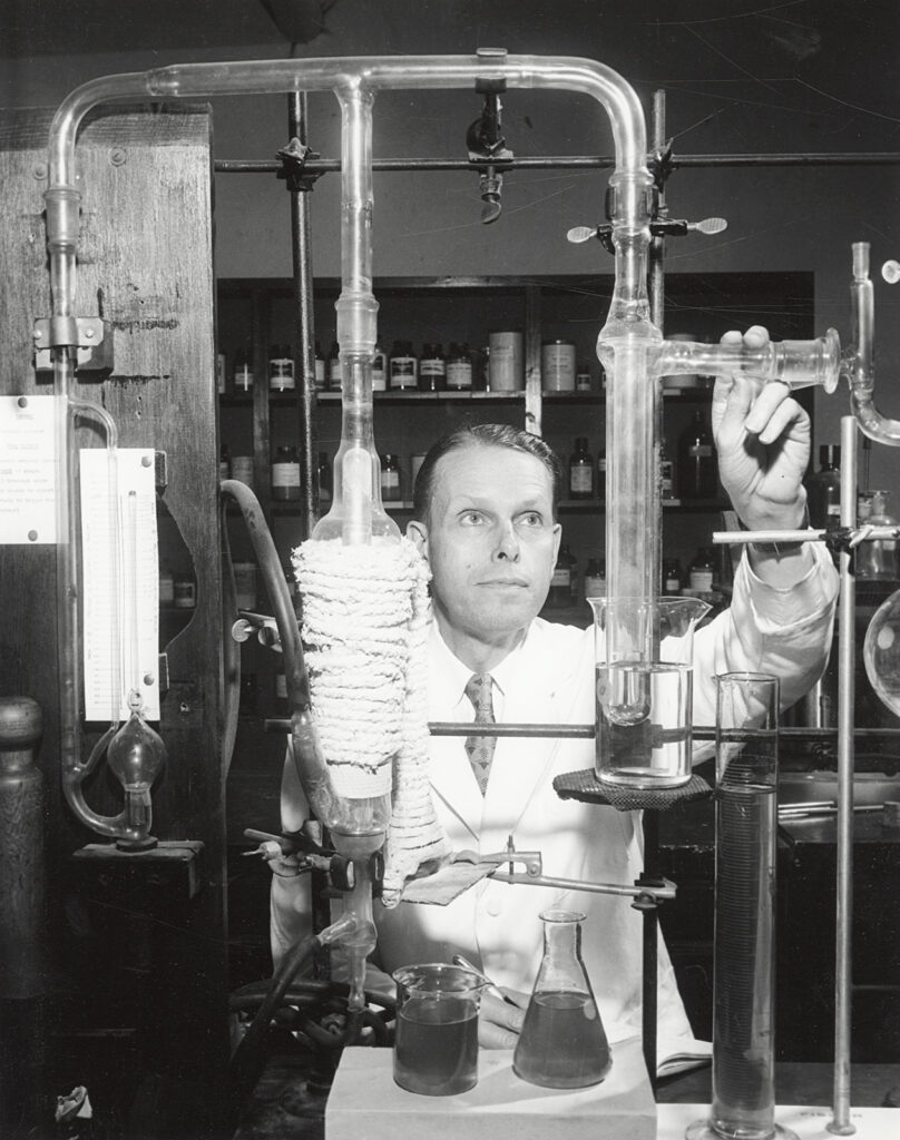 black and white photo of man with glass tubing