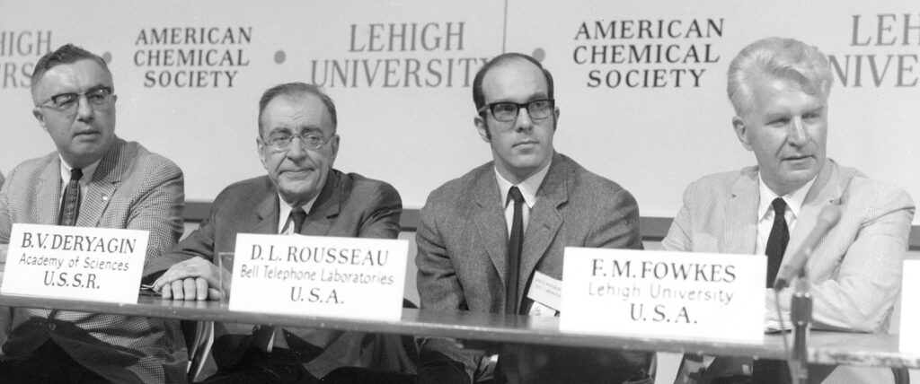 Four men sitting in front of microphones