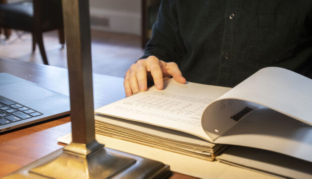 Hands turning a page in a bound book