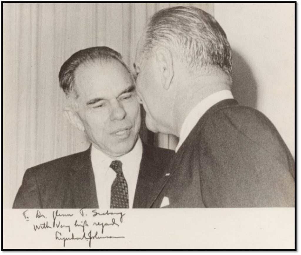 Glenn Seaborg with President Lyndon B. Johnson, 1968. Both wearing suits, Johnson leans over to talk to Seaborg. There's a handwritten not from Johnson to Seaborg on the photo.