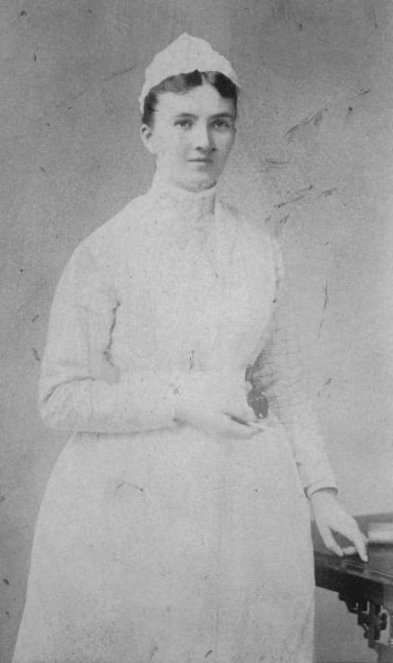 Photographic portrait of a standing woman in a nurse's uniform