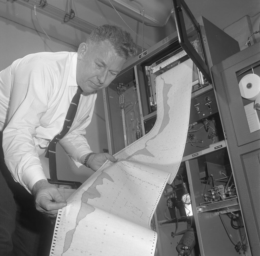Man holding a long printout of air-monitoring data