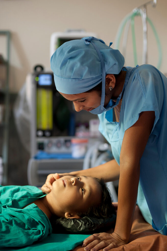 Nurse in scrubs touching a child's face