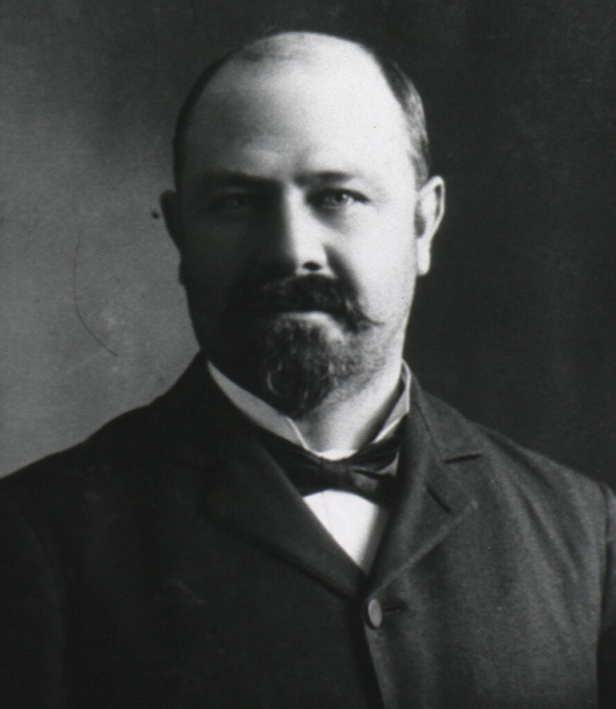 Black and white portrait of bald, bearded, white man