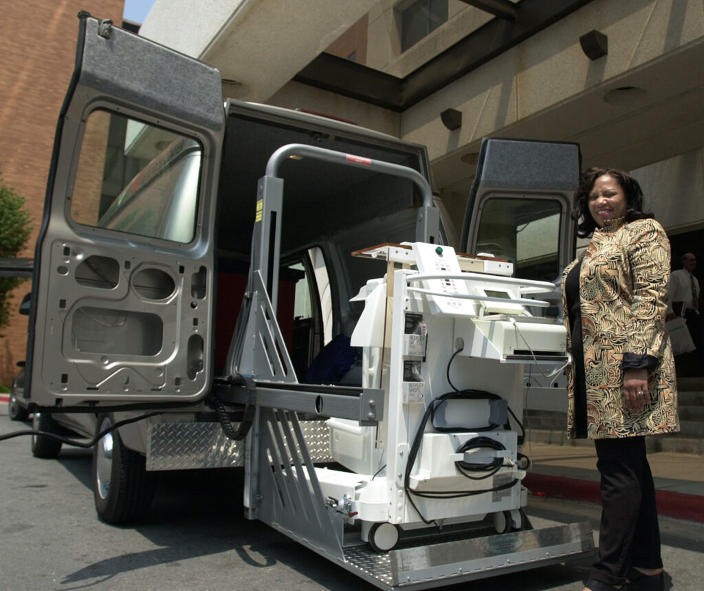 Woman standing with medical instrument outside van