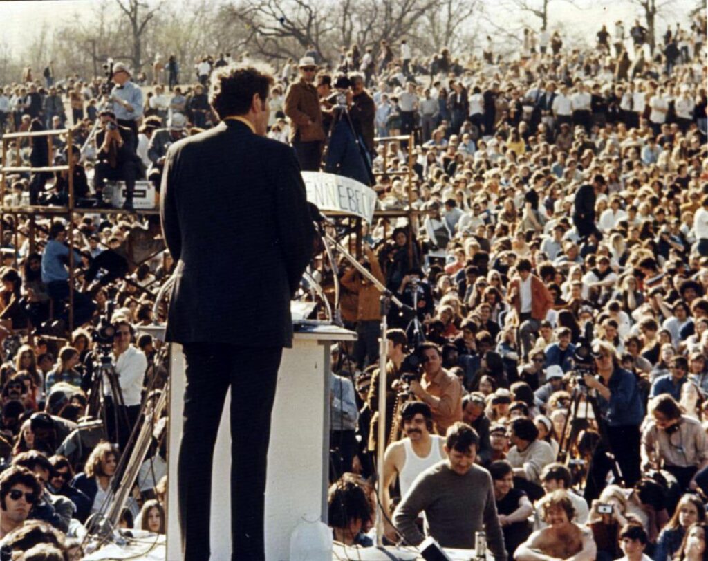 Man on stage in front of large crowd