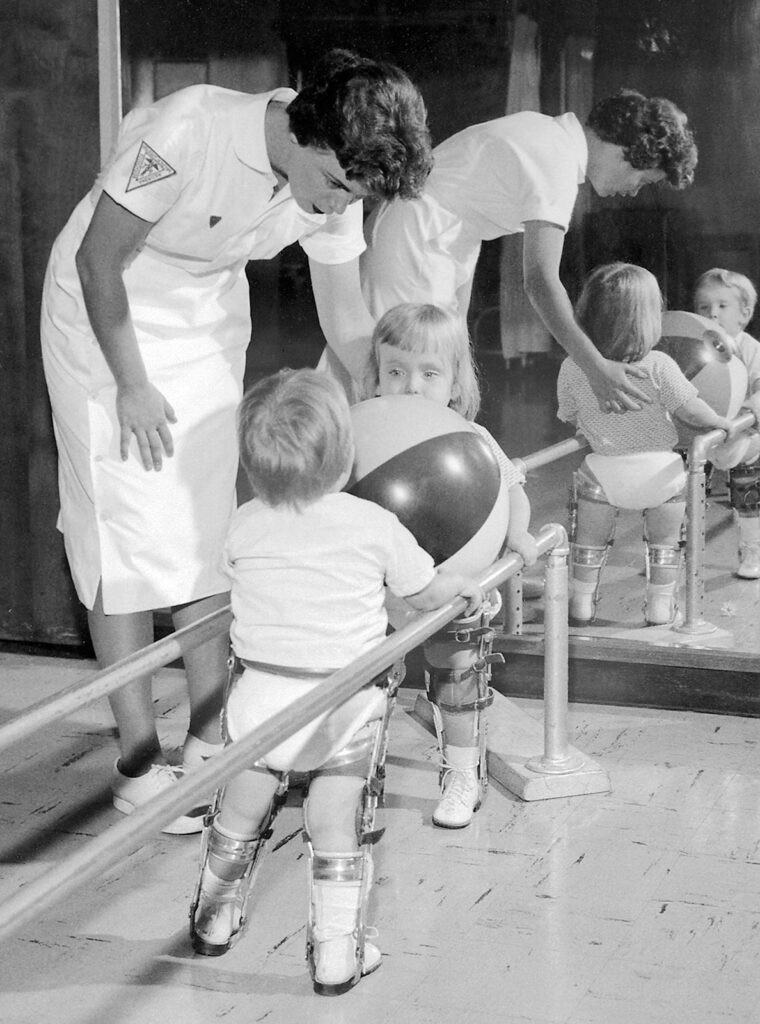 young children in leg braces working with a nurse