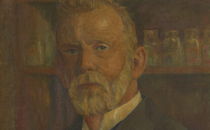 Painting of a older man with a white beard standing in front of shelves of medicine. He appears to be wearing an early 20th century suit.
