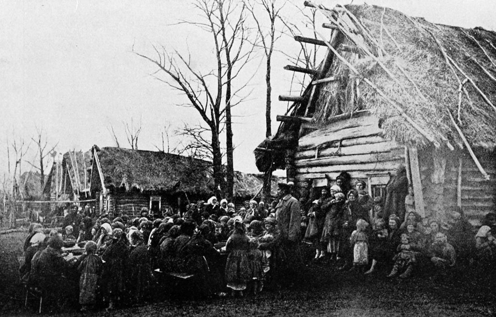 Grainy photo of a group of people in poor village