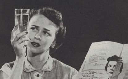 woman holding up a glass of water