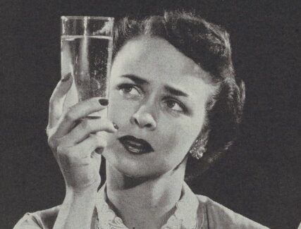 woman holding up a glass of water