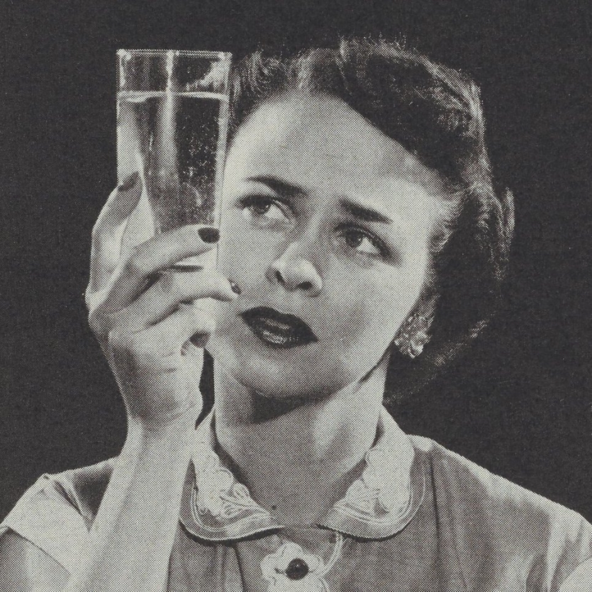 woman holding up a glass of water
