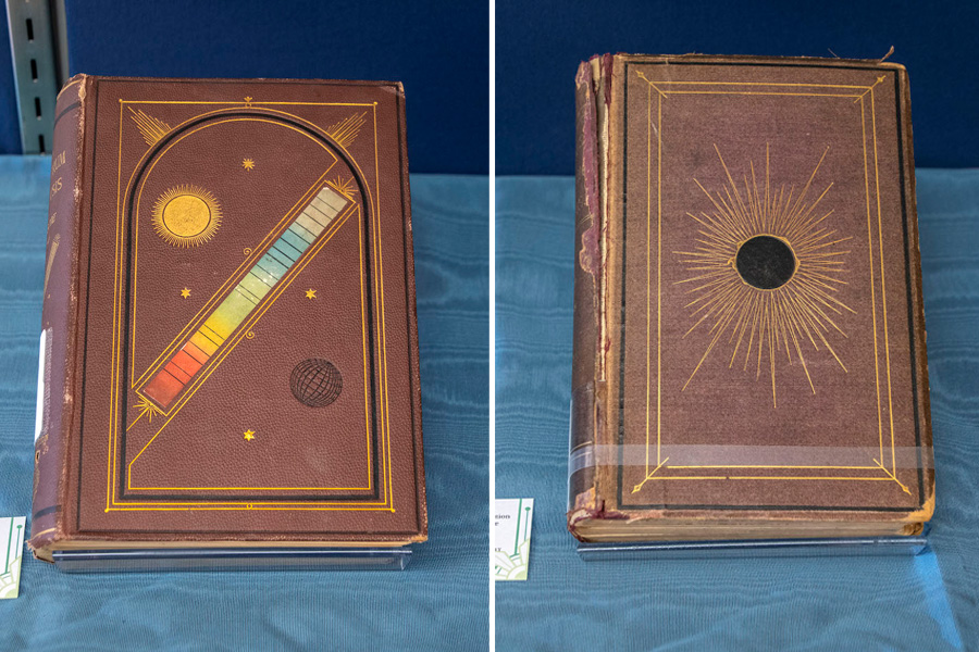 Two Spectrum Analysis books, bound in brown leather. One has a colorful spectrum and illustration of a sun. The other has a solar eclipse