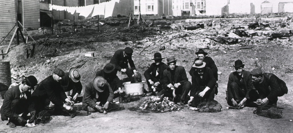 A group of twelve workers crouching and tying tags on dead rats