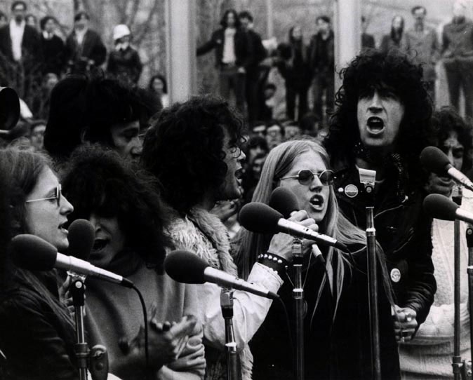 black and white photo of men and women singing