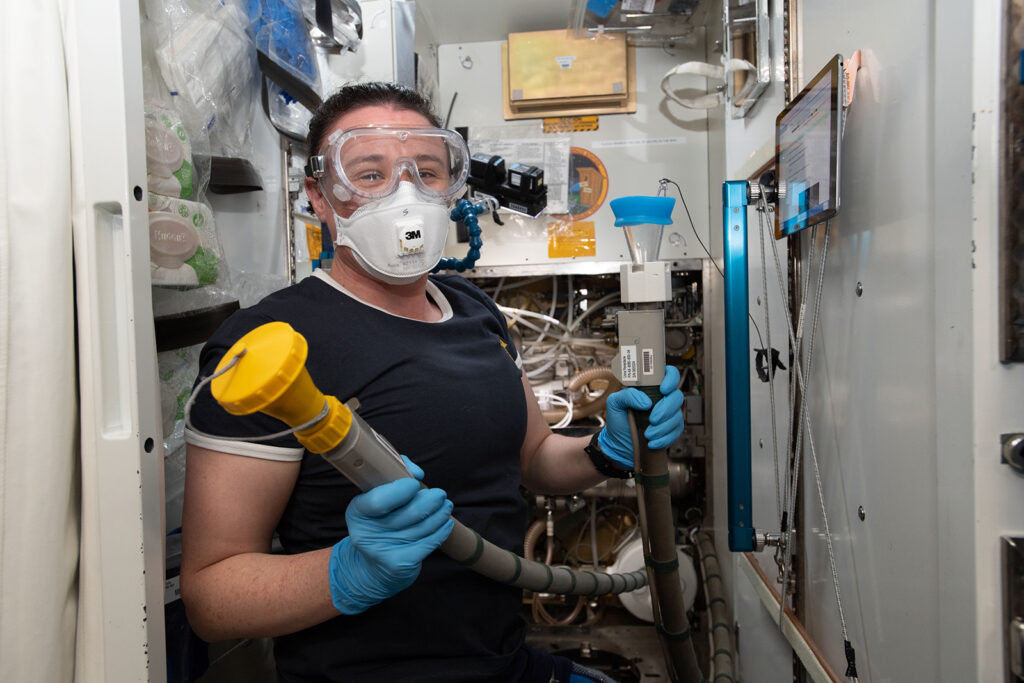 Masked woman holding tubes in a confined space