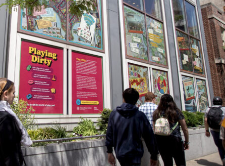 People walking near Playing Dirty outdoor exhibition