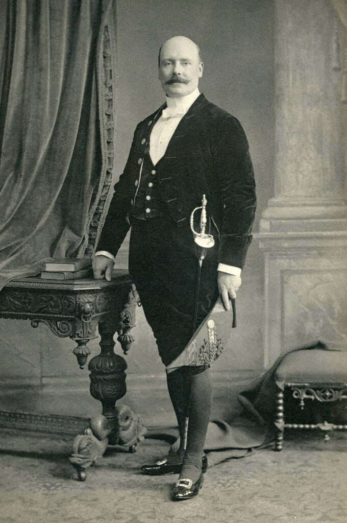 Black and white full body photo portrait of man in formal Edwardian court dress