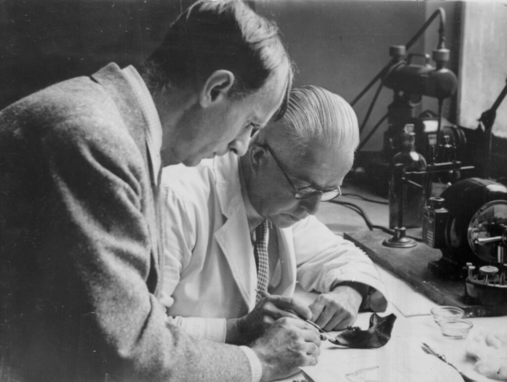Photo of two men inspecting something in a lab