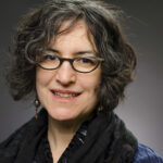 Amy Slaton studio portrait wearing glasses and black scarf