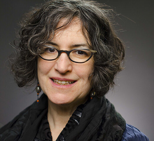 Amy Slaton studio portrait wearing glasses and black scarf