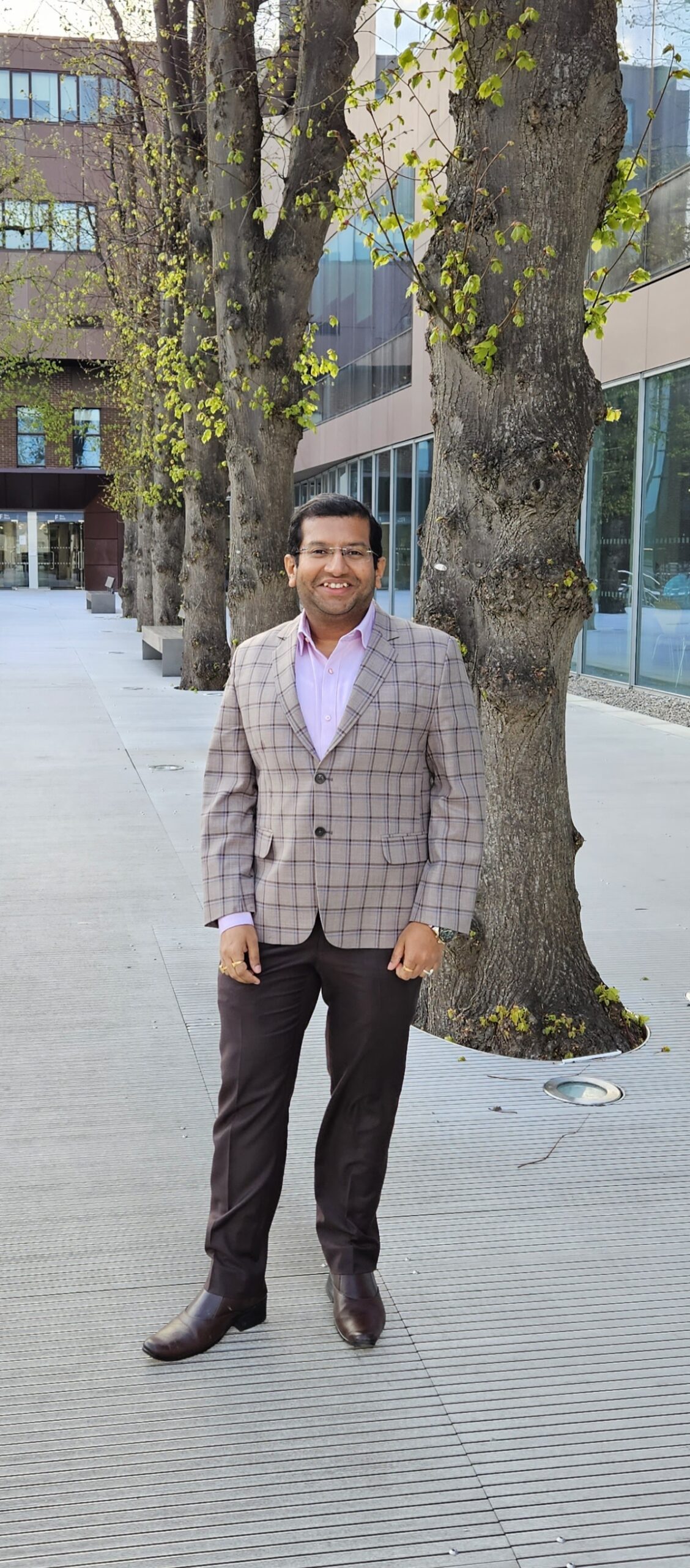 Arnav Bhattacharya standing in a plaza with trees