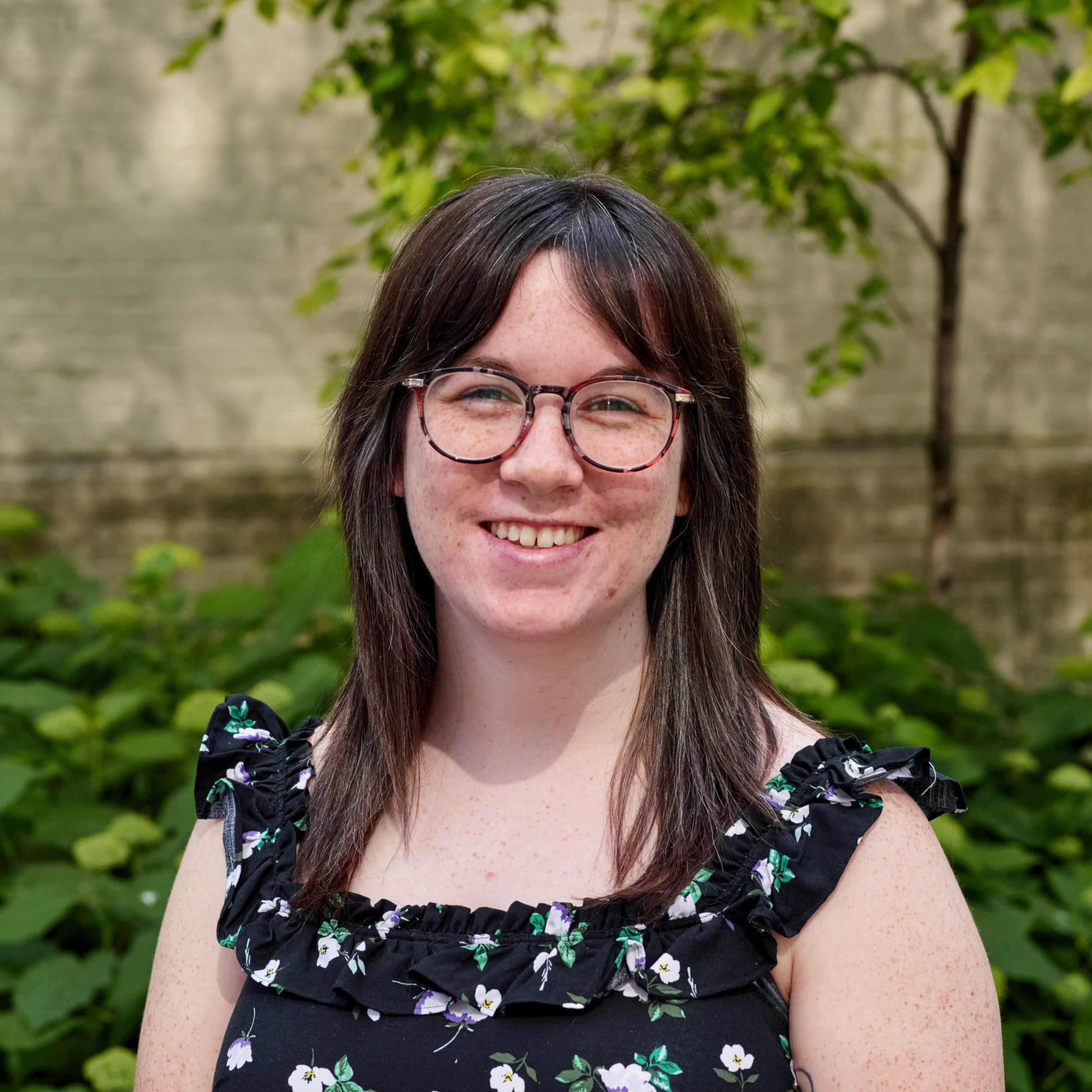 Caroline outdoors smiling with sleeveless floral top