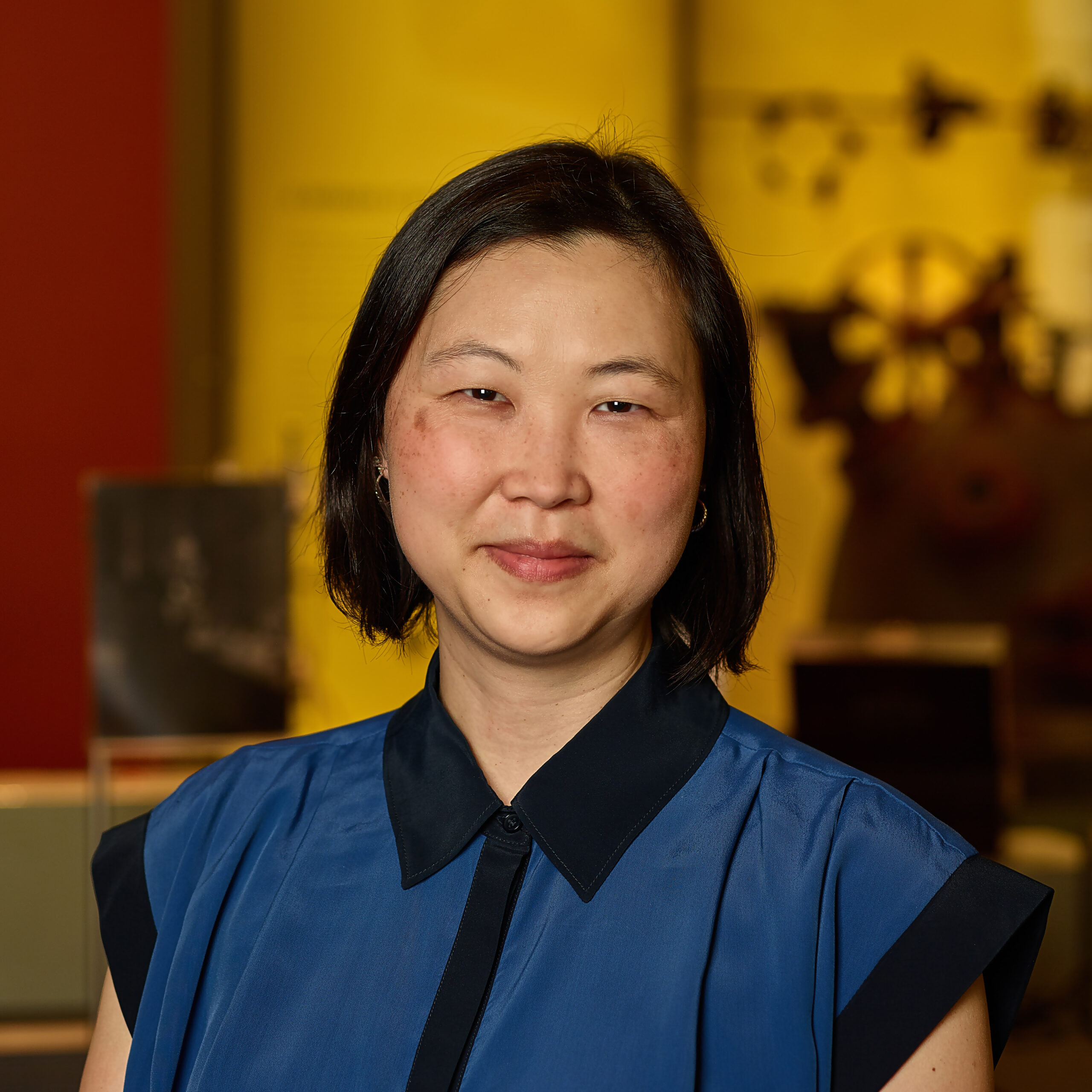 Molly in museum wearing blue and black collared shirt