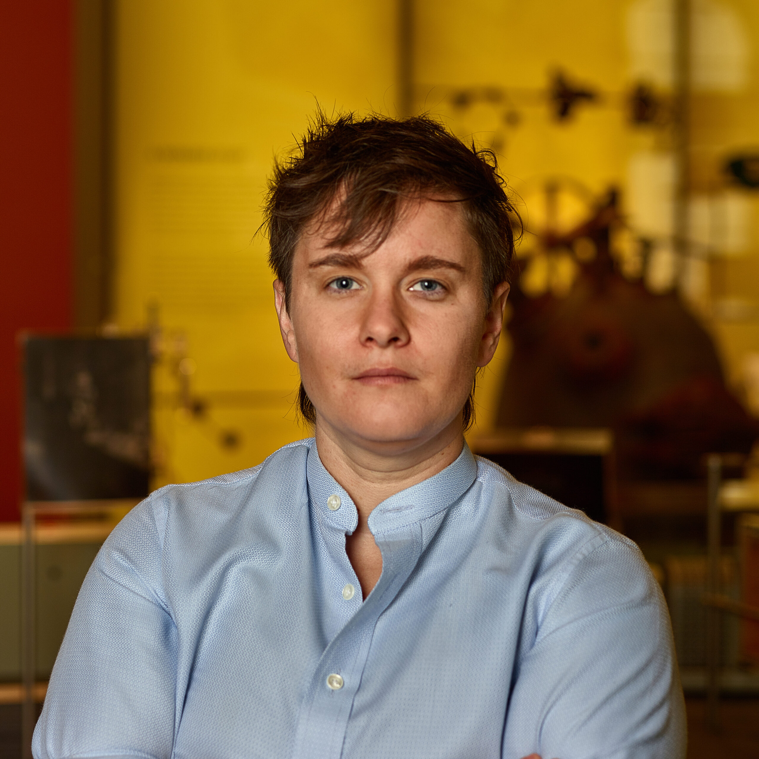 Sara in museum wearing light blue collared shirt