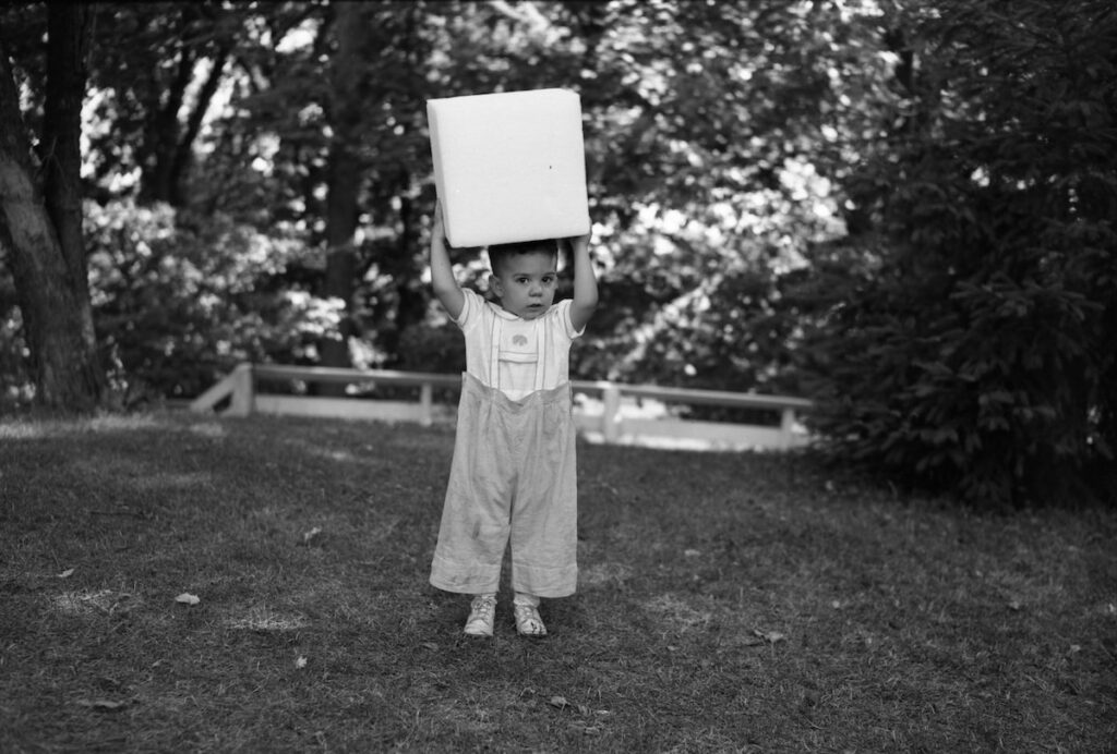 Child posed with block of Stryofoam, 1946