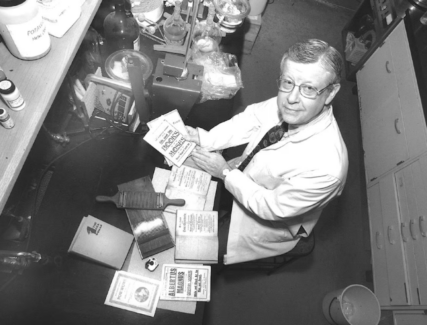 Ned Heindel with parts of his old medical collection including blood letting device and pill roller