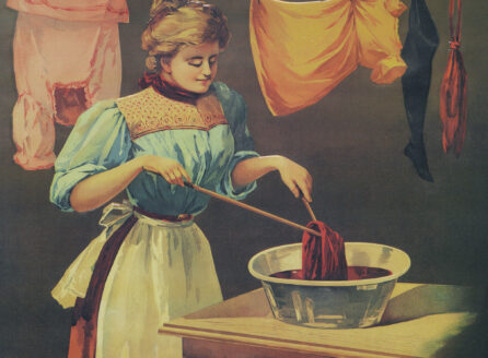 woman in apron dyeing cloth in a basin