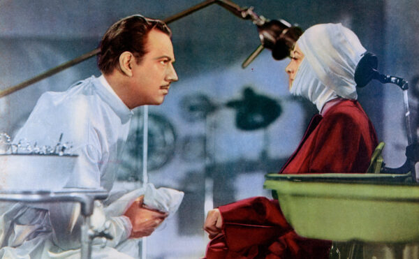 Movie poster with a colorized still of a doctor and woman with bandages around her head and face