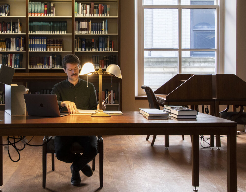 man doing research in a library