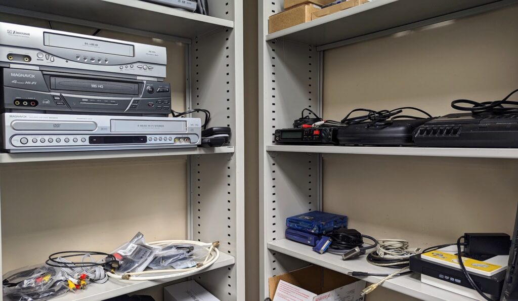 old computer hardware and cables on shelves