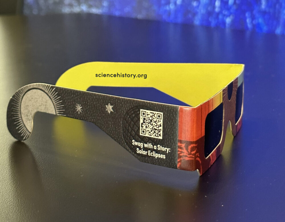 side view of colorful pair of eclipse glasses on a table in the museum gallery